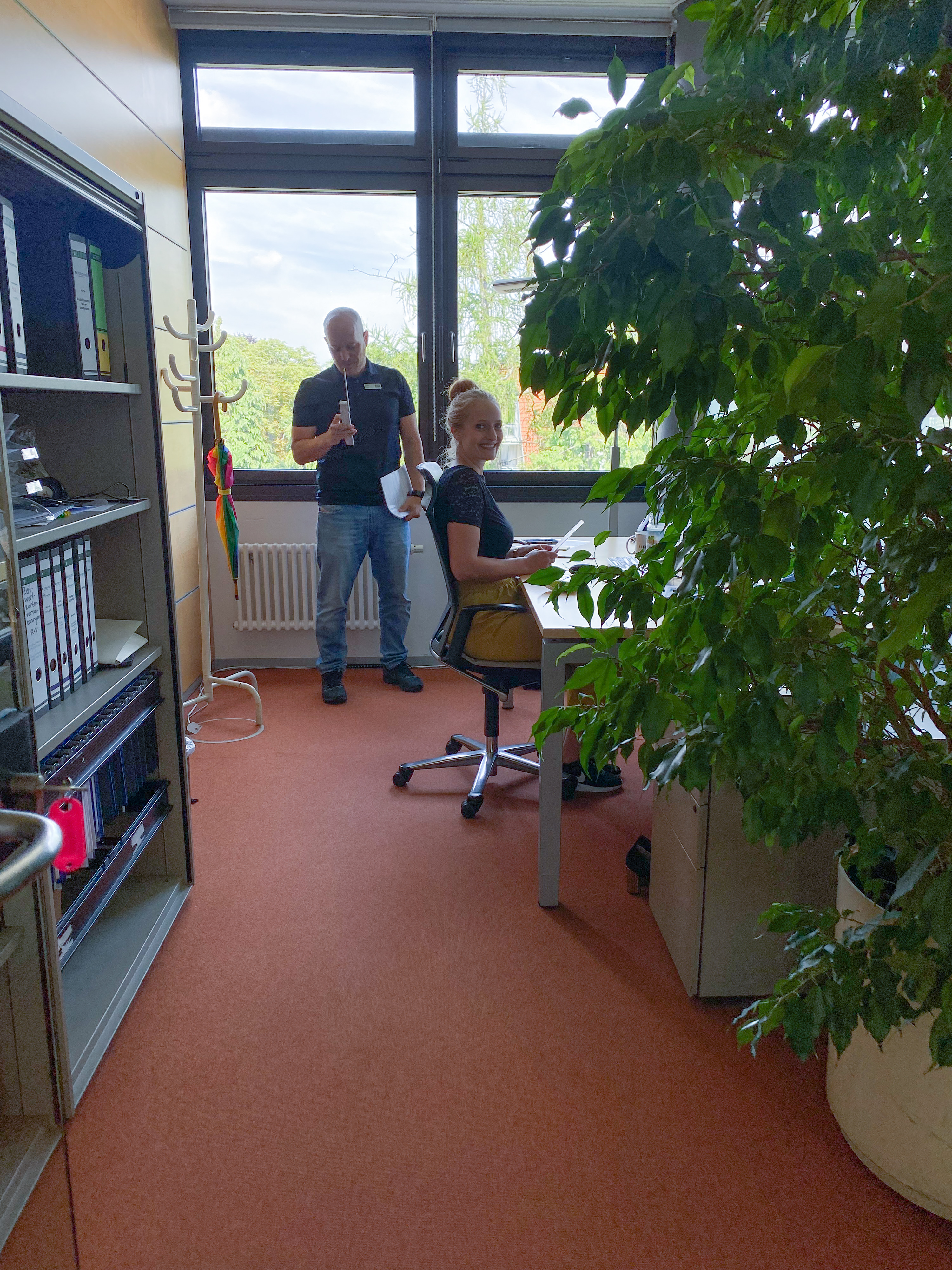 A trainer shows our colleague how to improve her posture while working at her desk